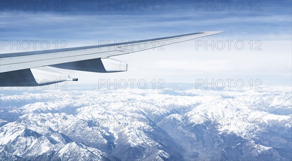 Switzerland, Canton Wallis, Airplane wing over snowy mountains
