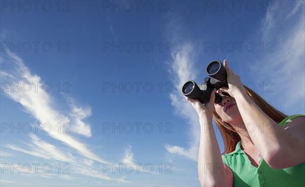 Young woman looking through binoculars