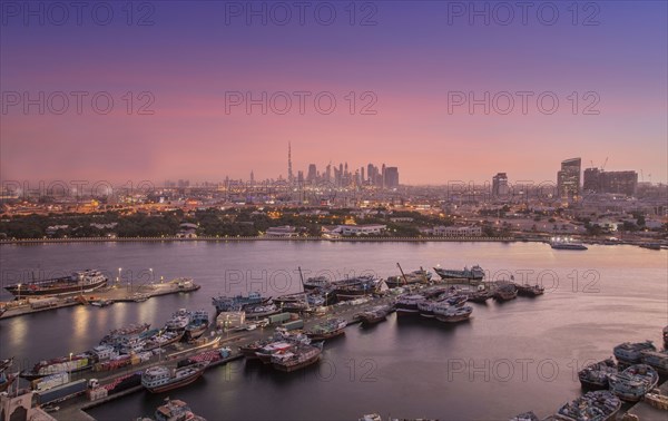 United Arab Emirates, Dubai, Boats on Dubai Creek and skyline at sunset