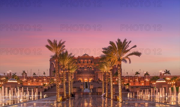 United Arab Emirates, Abu Dhabi, Palm trees and fountain in front of Hotel Emirates Palace