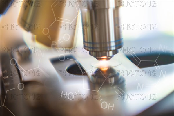 Close-up of laboratory microscope lens with chemical symbol