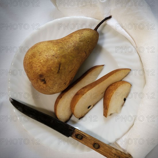 Sliced pear and knife on plate