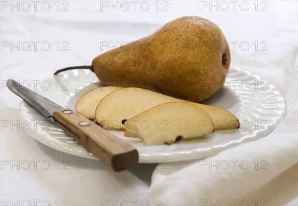 Sliced pear and knife on plate