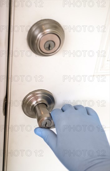 Hand with surgical glove opening door