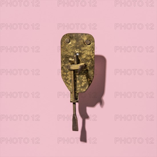 Antique Leeuwenhoek microscope on a pink background