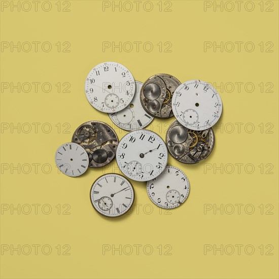 Retro watch faces and gears on yellow background