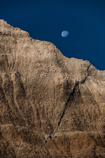 USA, South Dakota, Badlands National Park, Moon rising in Badlands National Park