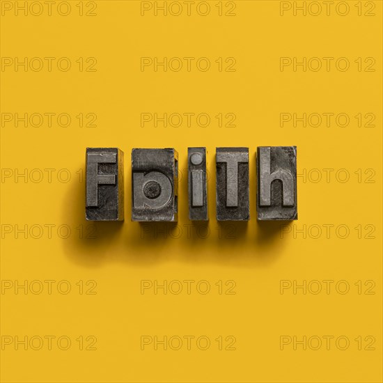 Wooden printer font letters spelling word Faith