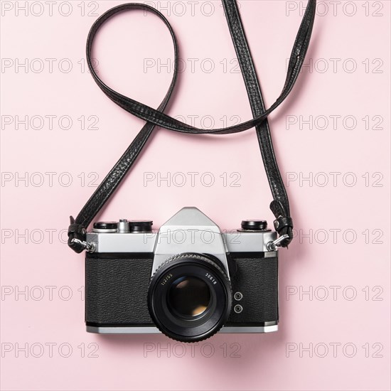 Vintage SLR camera on pink background