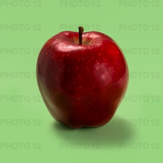 Red apple against green background