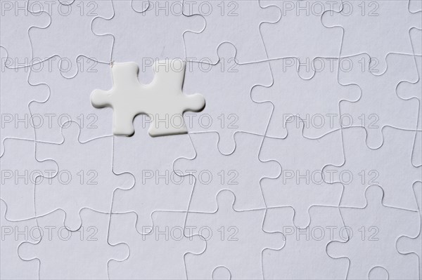 White jigsaw piece on jigsaw pattern
