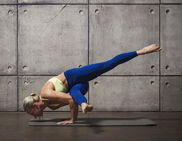 Woman doing handstand on mat