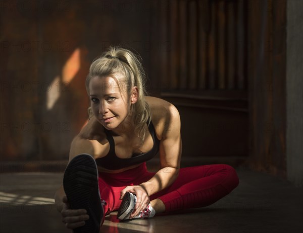 Sporty woman stretching on floor