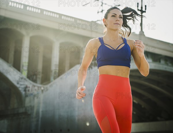 USA, California, Los Angeles, Sporty woman jogging in urban setting