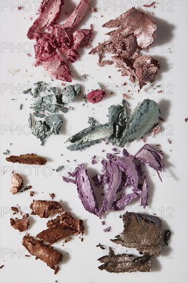 Crushed colorful eye shadows on white background