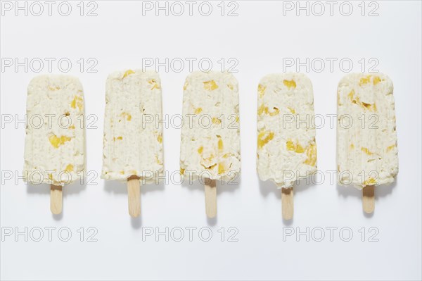 Rice and mango popsicle sticks on white background