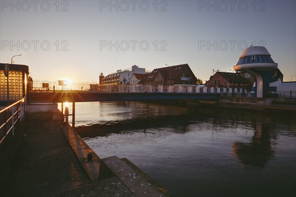 Poland, West Pomerania, Darlowek, Lighthouse and bridge over Wieprza River at sunset