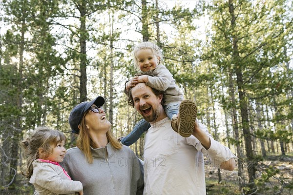 Happy parents carrying little daughters