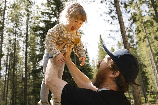 Father holding smiling daughter