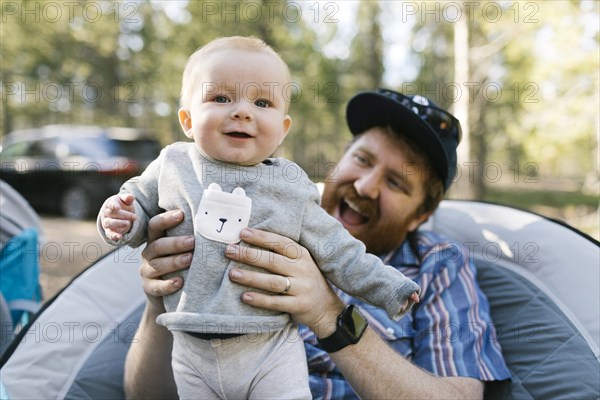 Smiling man holding baby son