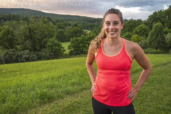 USA, Woman in running outfit standing in field