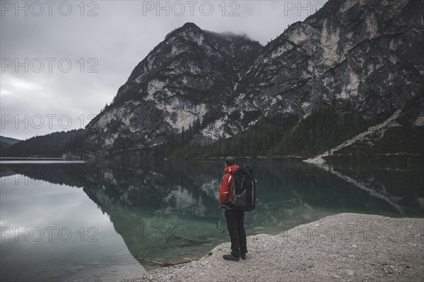 Italy, Pragser Wildsee, Dolomites, South Tyrol, Man looking at view standing near mountain lake