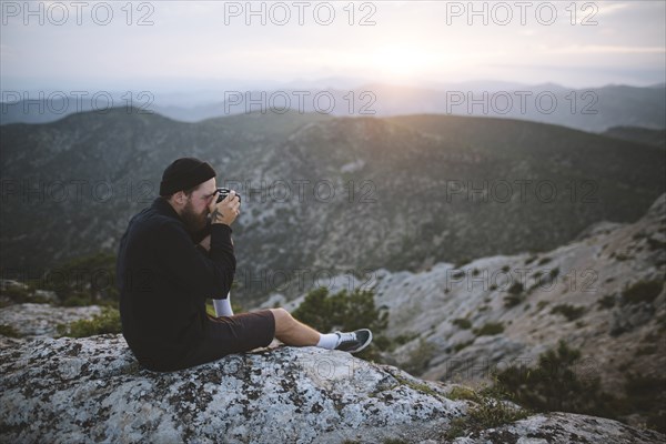 Italy, Liguria, La Spezia, Man photographing mountain range from mountain top