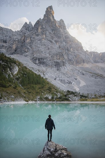 Italy, South Tyrol, Cortina d Ampezzo, lake Sorapis, Man standing on rock looking at lake