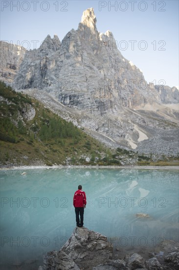 Italy, South Tyrol, Cortina d Ampezzo, lake Sorapis, Man standing on rock looking at lake