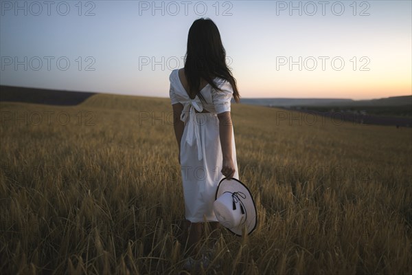 France, Woman in white dress standing in field