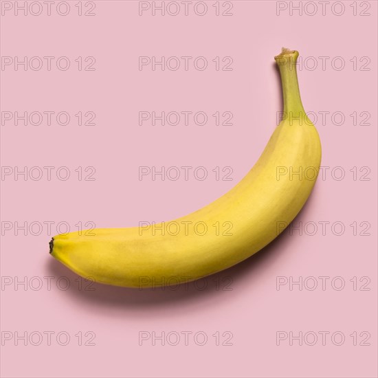 Ripe banana on pink background