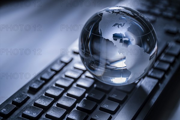 Glass globe on computer keyboard