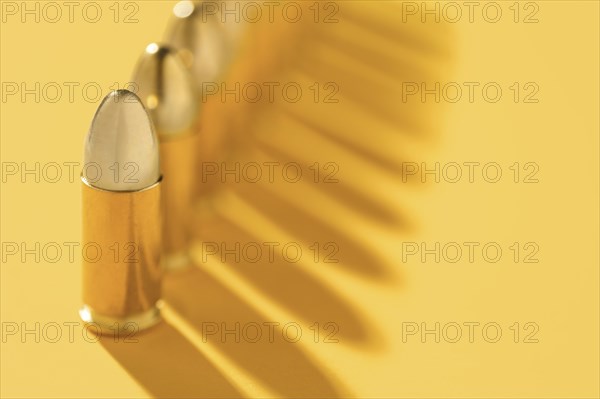 Row of gold bullets on yellow background