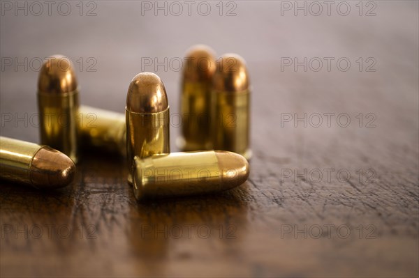 Gold bullets on wooden surface