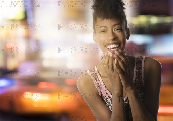 Portrait of young woman in city at night