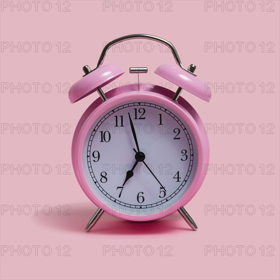 Alarm clock on pink background