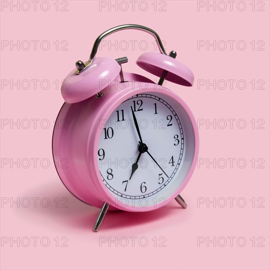 Alarm clock on pink background