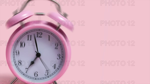 Alarm clock on pink background