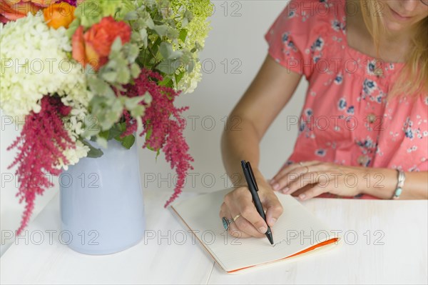 Woman writing in notepad