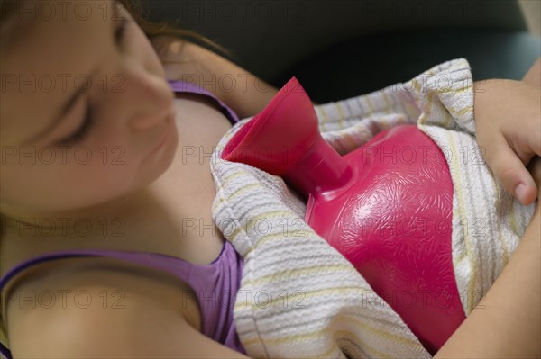 Girl (6-7) holding hot water bottle