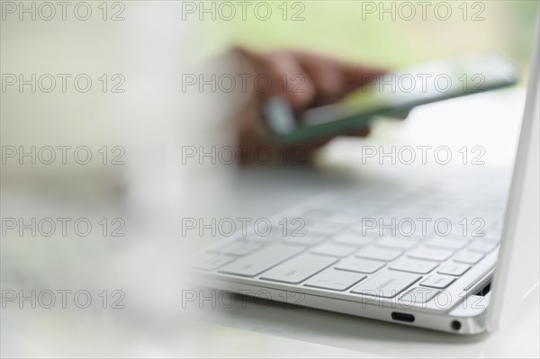 Woman's hands using laptop and smart phone