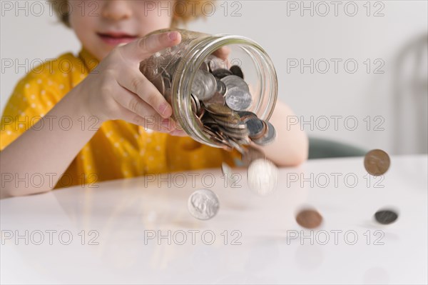 Boy (4-5) removing coins from jar