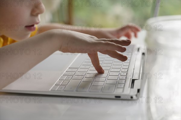 Boy (4-5) using laptop