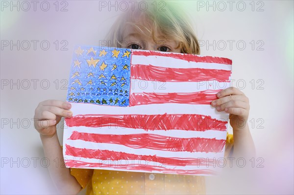 Boy (4-5) showing US flag drawn on paper