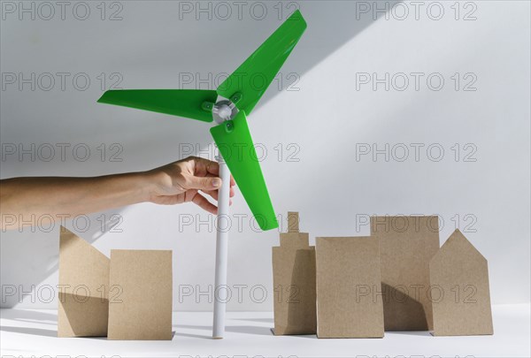 Woman's hand holding scale model of wind turbine