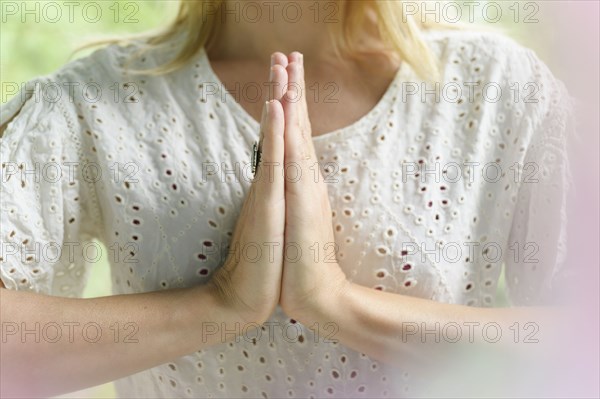 Close-up of blond woman doing yoga with hands clasped