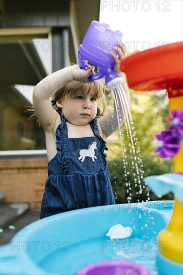 Toddler girl (2-3) playing with water in garden