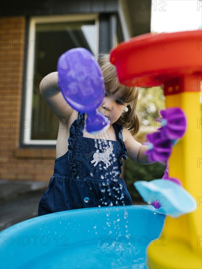 Toddler girl (2-3) playing with water in garden