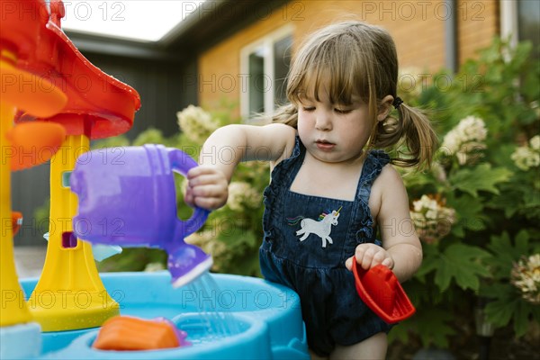 Toddler girl (2-3) playing with water in garden