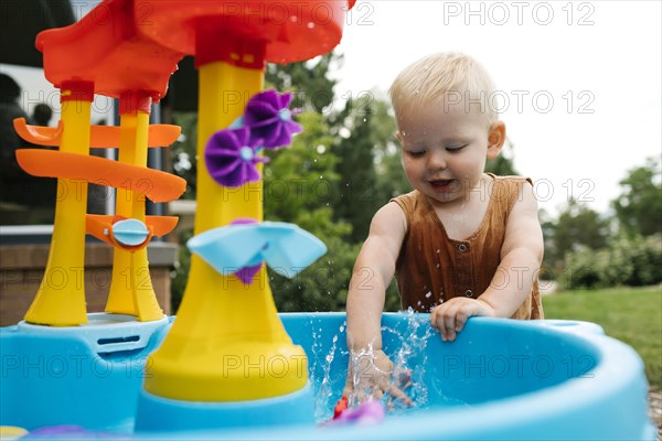 Baby boy(18-23 months) playing with water toys in garden